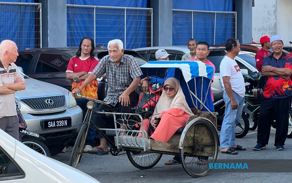 Octogenarian Pedals Trishaw Through Heat to Catch Glimpse of PM Anwar in Johor